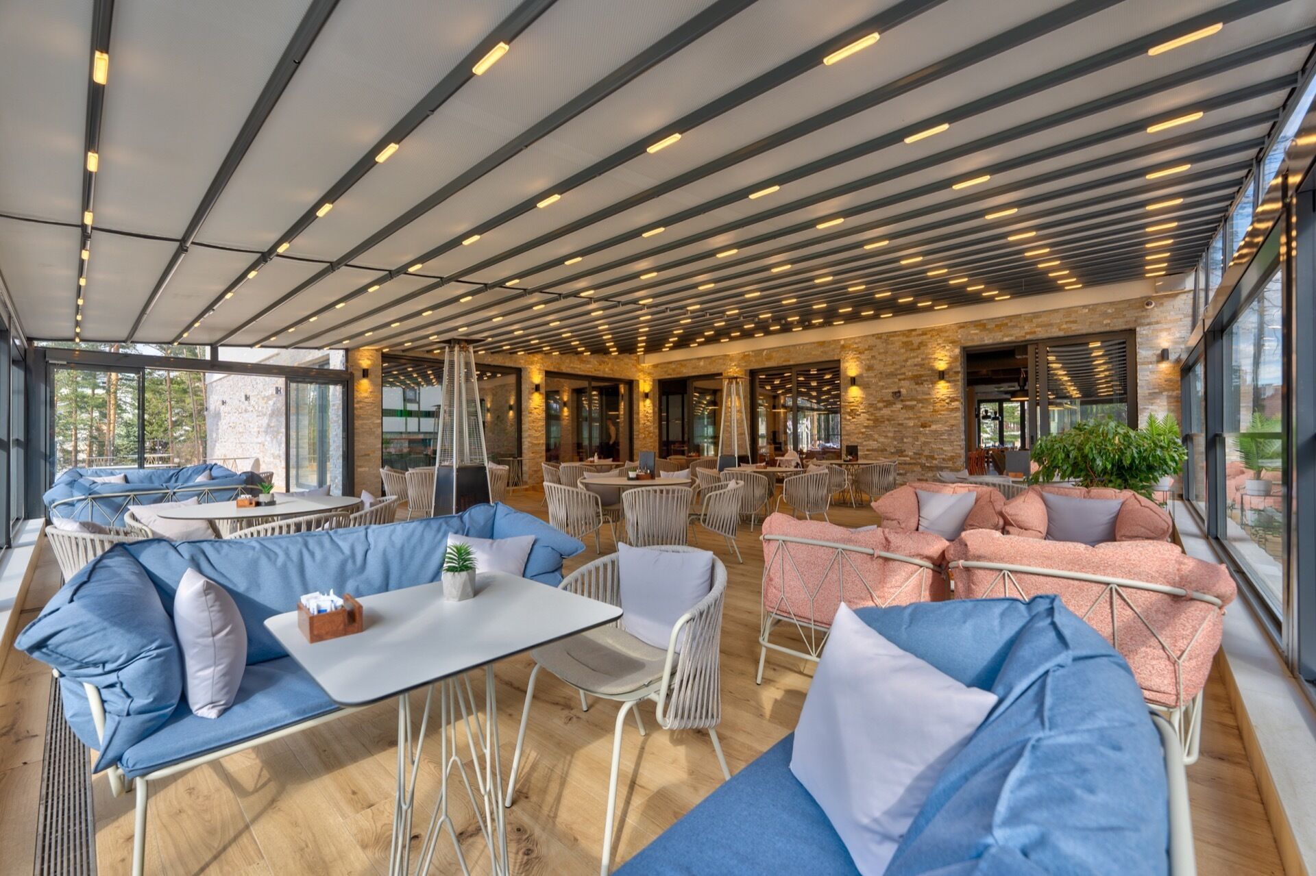 An outdoor seating area with tables and chairs, a staircase, and a view of the outdoors.