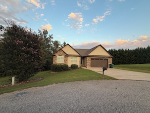 A two-story house with a garage, surrounded by a well-maintained lawn and trees.