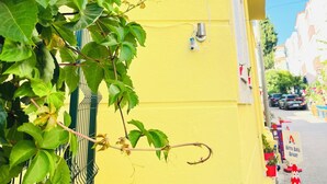 A yellow building with a sign reading 'ASYA ASIL APART' and a security camera.