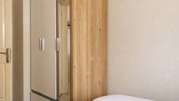A bedroom with a bed, a wardrobe, and a door.
