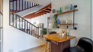 A staircase with wooden railings, a wooden counter with stools, and a wall-mounted shelf with decorative items. - Holiday Home in Nerja With Sea Views & Pool (Nerja)