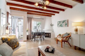 Ein geräumiges Wohnzimmer mit Kamin, Essbereich und einer Sitzecke mit Sofa und Sesseln.