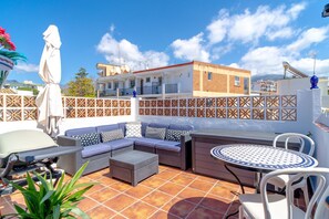 A rooftop terrace with a sofa set, a dining table, and a chair. - Holiday Home in Nerja With Sea Views & Pool (Nerja)