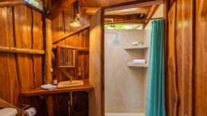 Un bagno in legno con lavandino, WC e tenda della doccia.