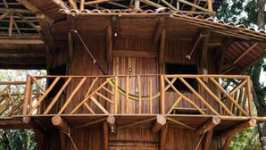 Una struttura in legno con un balcone e un'amaca.