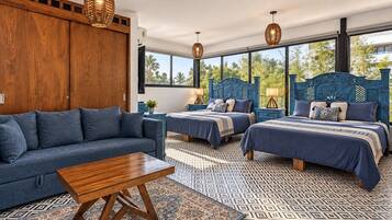 A bedroom with two beds, a sofa, and a coffee table.