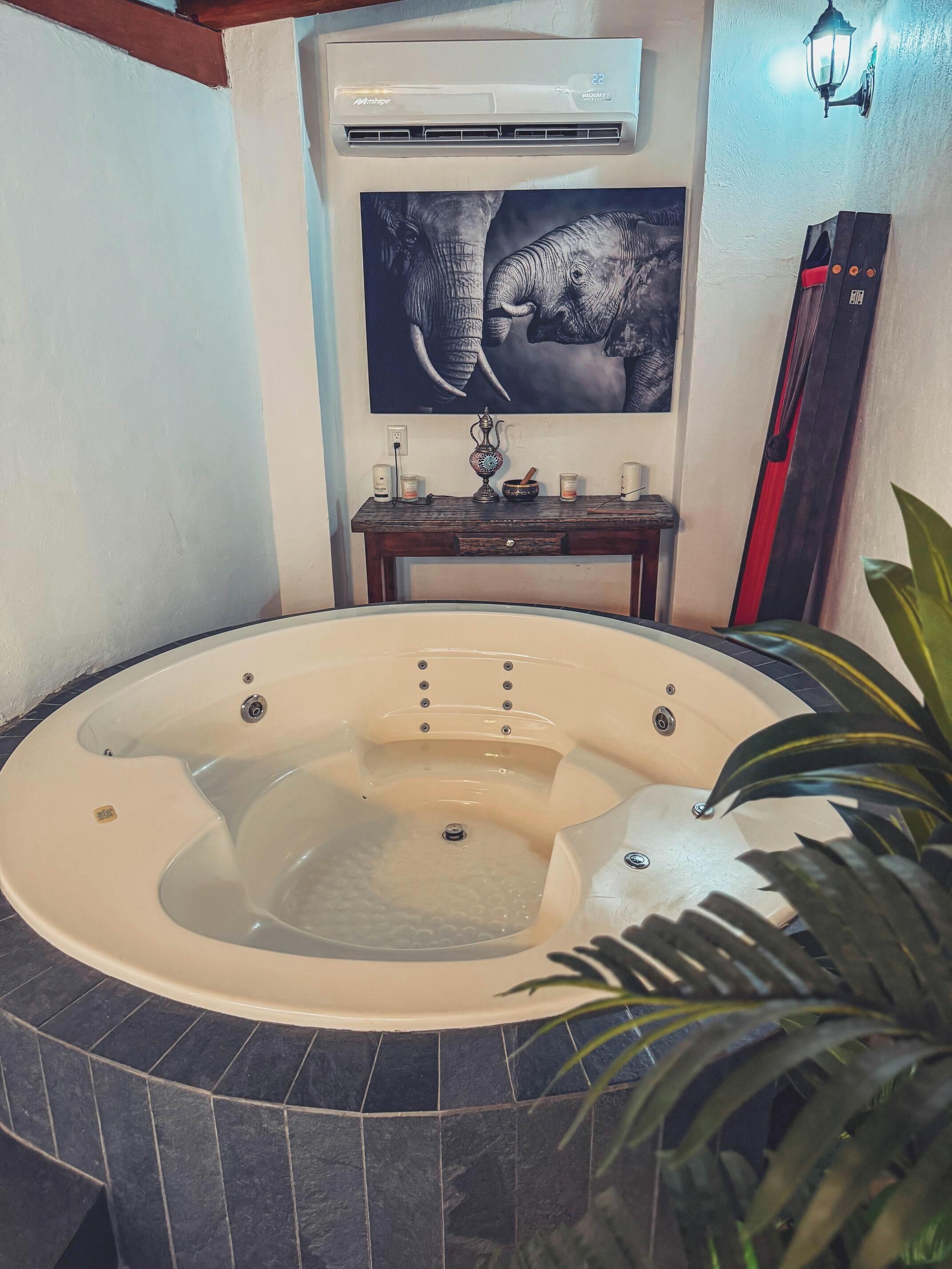 Un bain à remous avec une table en bois et des objets décoratifs en arrière-plan.