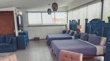 Un dormitorio con dos camas, una mesa de madera y un suelo con diseño.
