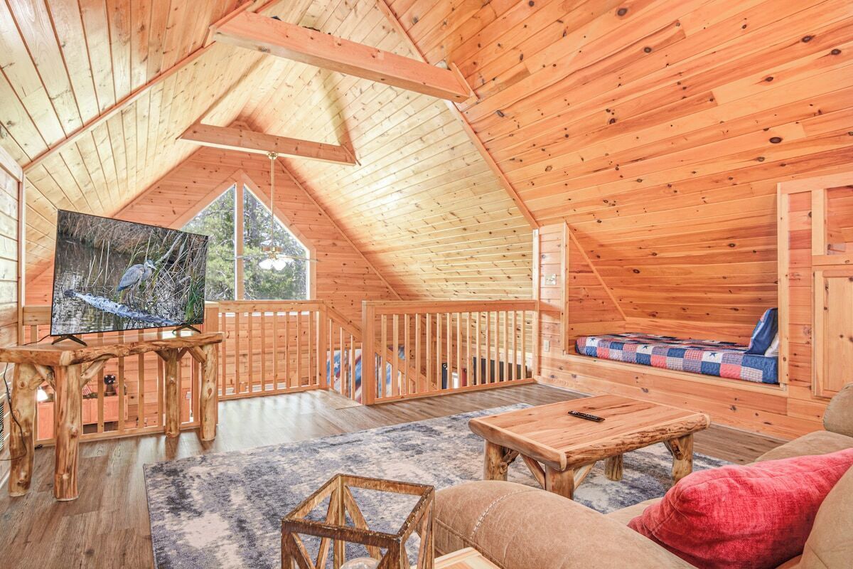 A cozy wooden interior with a television, a sofa, and a wooden table.