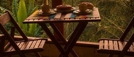 Mesa para dos con vista a un atardecer y follaje tropical.