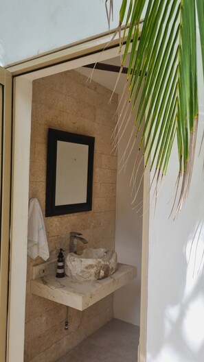Ein Badezimmer mit Marmorwaschbecken, einem Spiegel und einem Handtuch an der Wand.