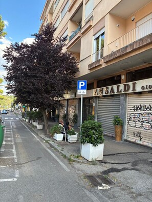 Straßenansicht mit einem Gebäude mit der Aufschrift 'ANSALDI GIO' und einem Parkschild.