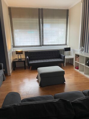 A living room with a sofa, ottoman, and two side tables with lamps. - The Blue Nest Near St. Peter's Basilica (Roma)