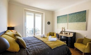 A bedroom with a bed, a desk, two chairs, a window, and artwork on the wall. - COMBINING TIMELESS CHARACTER WITH MODERN COMFORT IN A PRIME LOCATION (Cannes)