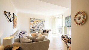 A modern living room with a sofa, coffee table, and artwork. - COMBINING TIMELESS CHARACTER WITH MODERN COMFORT IN A PRIME LOCATION (Cannes)