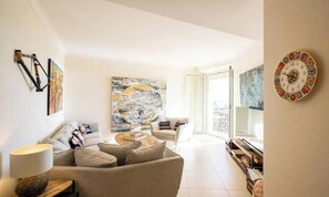 A modern living room with a sofa, coffee table, and artwork. - COMBINING TIMELESS CHARACTER WITH MODERN COMFORT IN A PRIME LOCATION (Cannes)