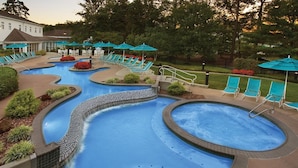 Un'area piscina con diverse vasche idromassaggio e lettini.
