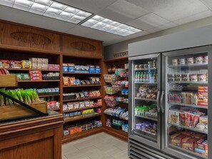 A grocery store interior with shelves stocked with various food items, a refrigerated section, and a wooden display area. - Marriott's Fairway in New Jersey 2 Bedroom Villas (Galloway)