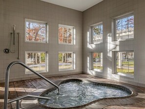 A spa room with a hot tub, large windows, and a wooden floor. - Marriott's Fairway in New Jersey 2 Bedroom Villas (Galloway)