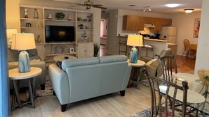 Ein Wohnzimmer mit einer Couch, einem Fernseher und Dekoration.