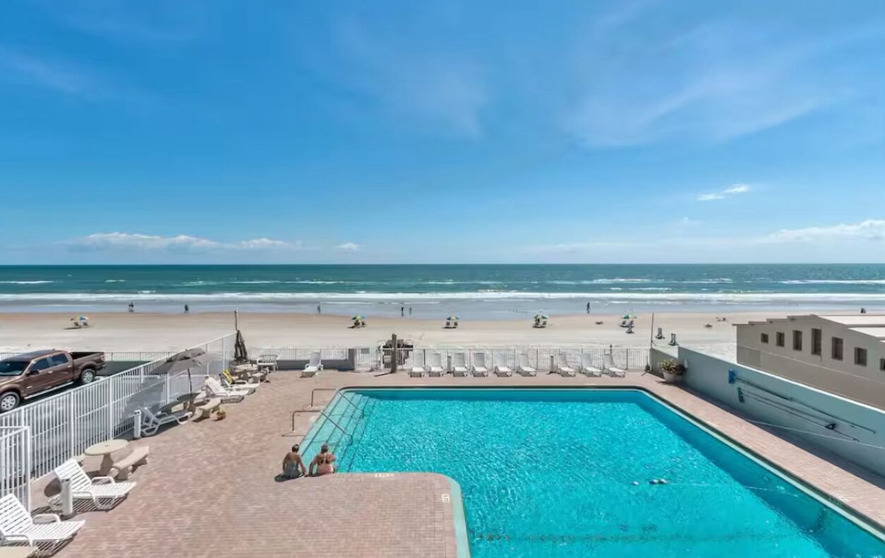 A swimming pool with a view of the beach and ocean.