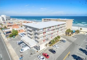 A multi-story hotel with a parking lot and ocean view. - New Wonderful Beach Front Studio in Daytona Beach! (Daytona Beach)