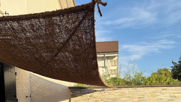 Ein Essbereich im Freien mit Tisch, Stühlen und einem überdachten Sitzbereich.