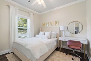 A bedroom with a bed, a desk, a chair, a mirror, and a window with curtains. - Meet Me In Oxford- 3BR -1 Mile from the Square (Oxford)