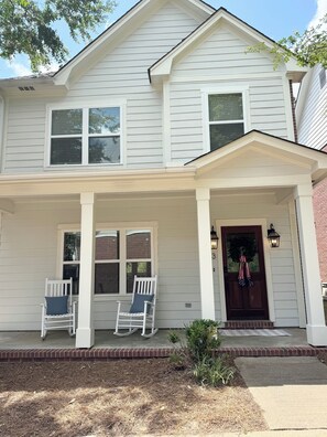 A two-story house with a porch, two rocking chairs, and a front door with a wreath. - Meet Me In Oxford- 3BR -1 Mile from the Square (Oxford)
