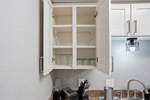 Eine Küche mit einem weißen Schrank, einem Toaster, einem Mixer und einer Spüle.