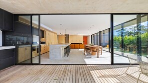 Une cuisine moderne dotée d’un îlot central, de meubles en bois et d’un coin repas avec une table et des chaises.