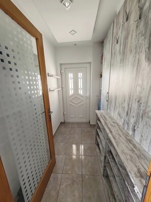A hallway with a wooden door, a white door with a geometric window design, and a wardrobe with a textured surface. - EXPO 2027, Free Airport Shuttle, EV & Parking (Beograd)