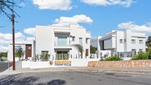 Moderni huvilakokonaisuus, jonka yhteydessä on kyltti, jossa lukee: ”Sun & Moon Luxury Villas”.