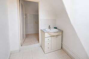 A bathroom with a white sink, a mirror, and a shower area. - Dar El Medina (Casablanca)