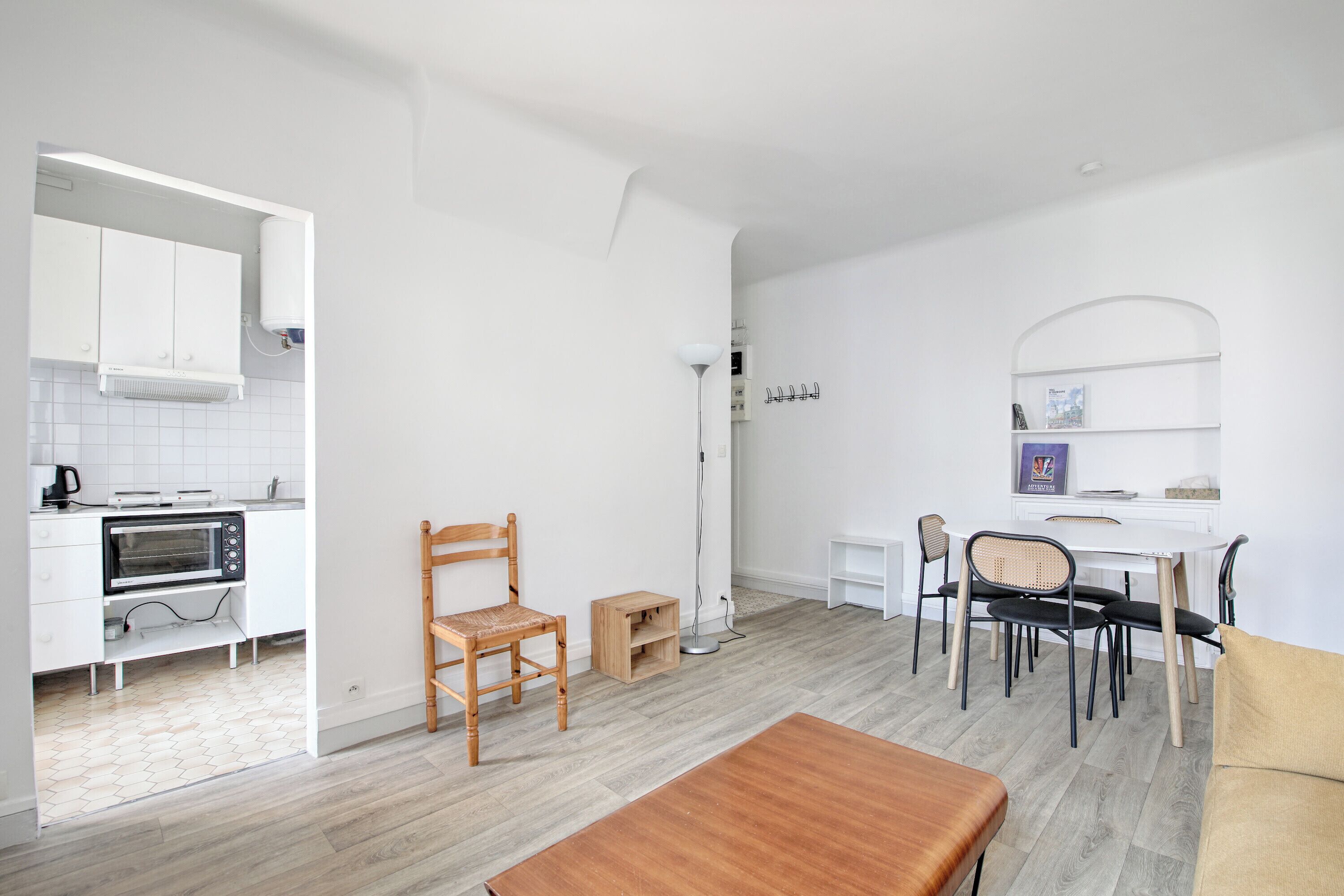 A compact living space with a kitchenette, dining area, and a small seating area.