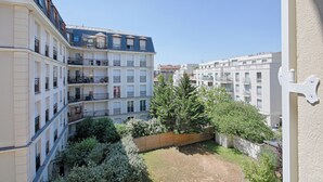 Um edifício residencial de vários andares, com varandas e um pátio.