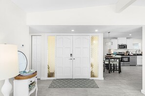 A modern kitchen with white cabinets, a microwave, and a dining area with chairs. - Spacious 3 Bedroom Waterfront Home with Private Backyard and Water Access in Port Charlotte (Port Charlotte)