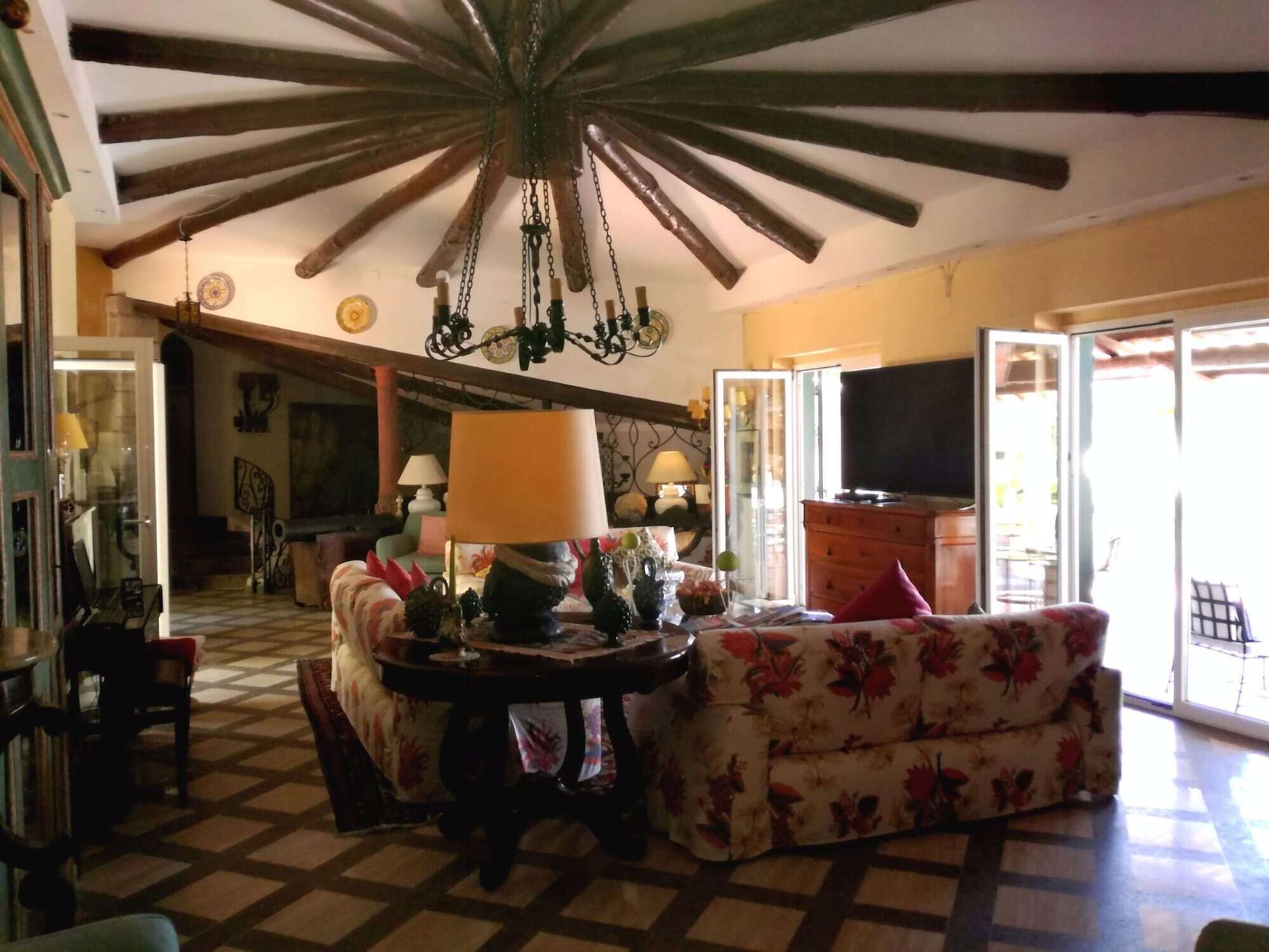 A living room with a checkered floor, a chandelier, a sofa, and a television.