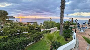 Un jardín ajardinado con vistas al mar al atardecer.