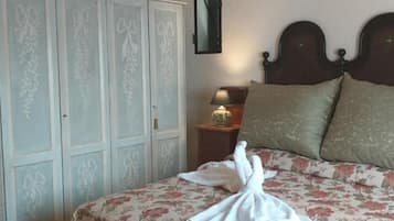 Una camera da letto con un letto, un armadio, un comodino e una lampada.