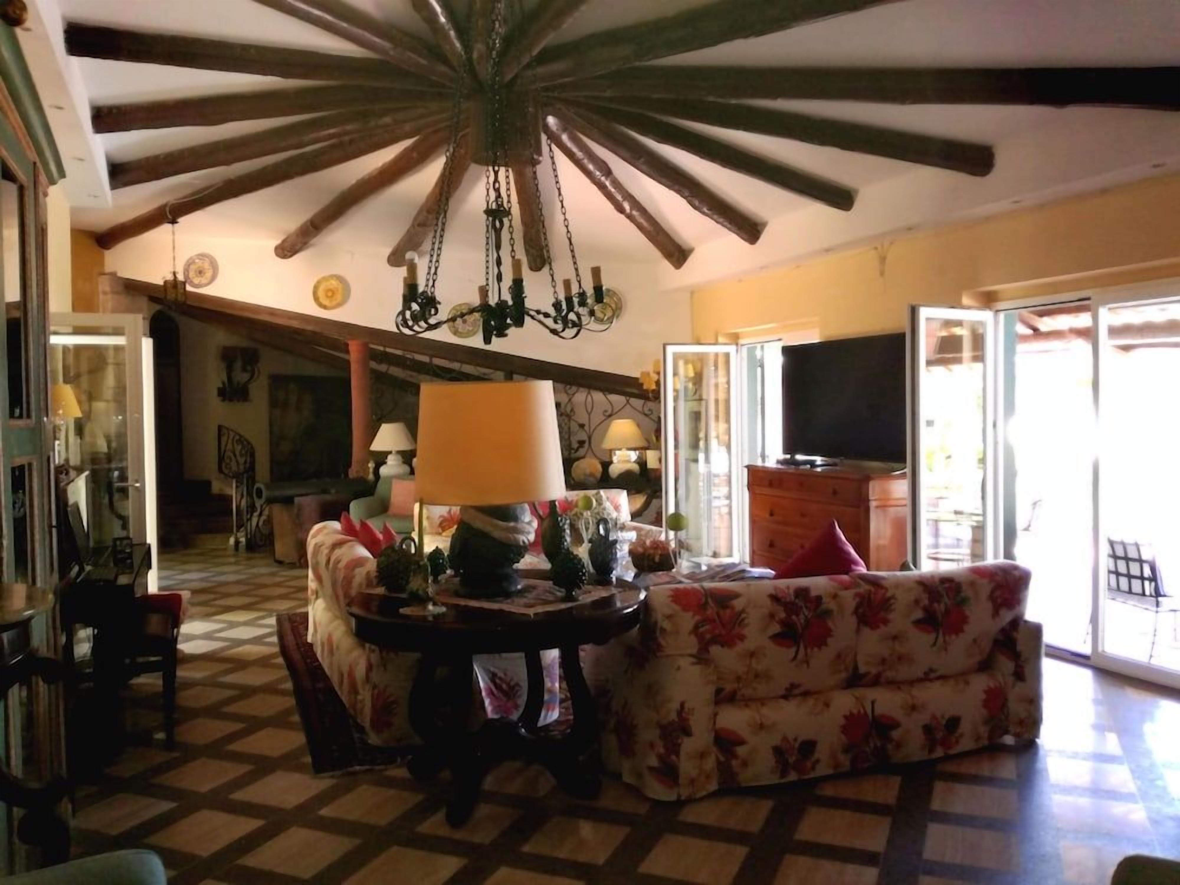A living room with a checkered floor, a chandelier, a sofa, and a television.