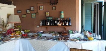 Una mesa servida con diversos alimentos y botellas, probablemente para una reunión o evento.