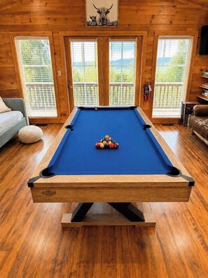 A pool table in a room with wooden floors and large windows. - The Overlook-Luxury Cabin Mtn View Walk to Parkway (Pigeon Forge)