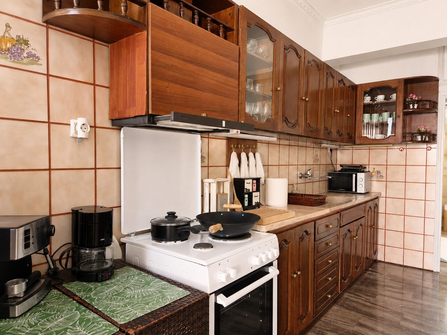 A kitchen with wooden cabinets, a white stove, a coffee maker, and a microwave.