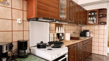 A kitchen with wooden cabinets, a white stove, a coffee maker, and a microwave.