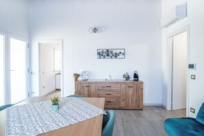 Eine moderne Küche mit einem Holzkabinett, einem Esstisch mit gemustertem Tischlauf und einer an der Wand befestigten Uhr.