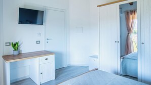Makuuhuoneessa on sänky, seinälle asennettu televisio, yöpöytä ja vaatekaappi.