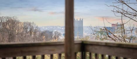A cityscape with a prominent building in the distance, viewed through a wooden railing.