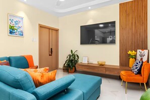 Un salon moderne avec un canapé, une table basse et un téléviseur fixé au mur.