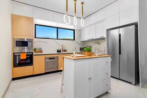 A modern kitchen with a built-in oven, microwave, and refrigerator. - Paradisiac Euphoria~ Beach Access~Pool~24hr Gated (St. Ann Parish)